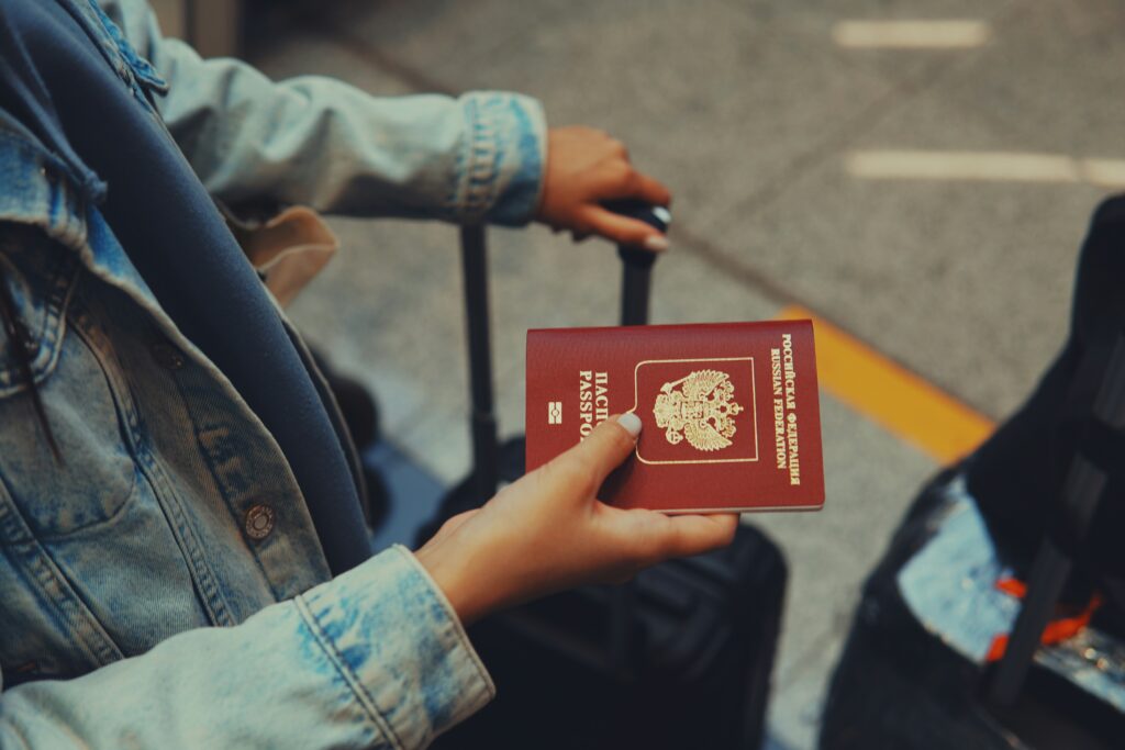 A women holding a passport while waiting in line at the airport
