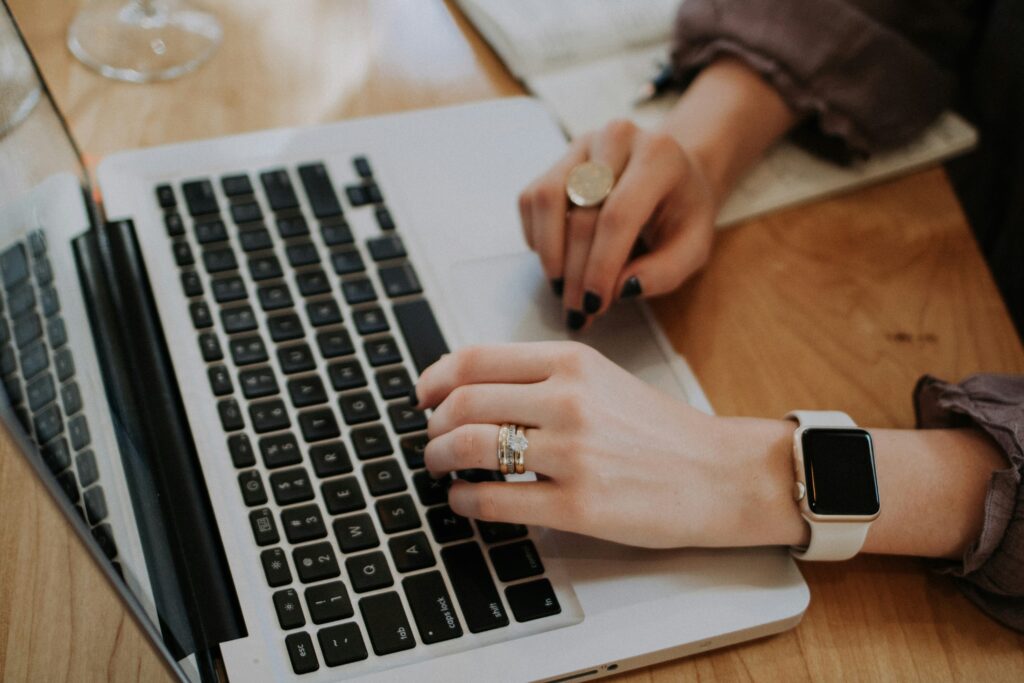 a women typing on a laptop while filling out an online profile