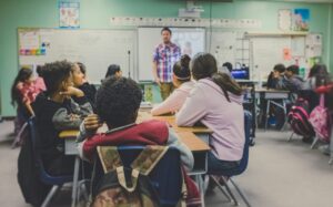 a man teaches English to a classroom of students overseas