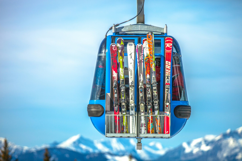 close up of a blue ski gondola with skis hanging on the outside