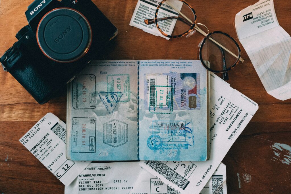 Passports, visa, and plane tickets laying on a table. 