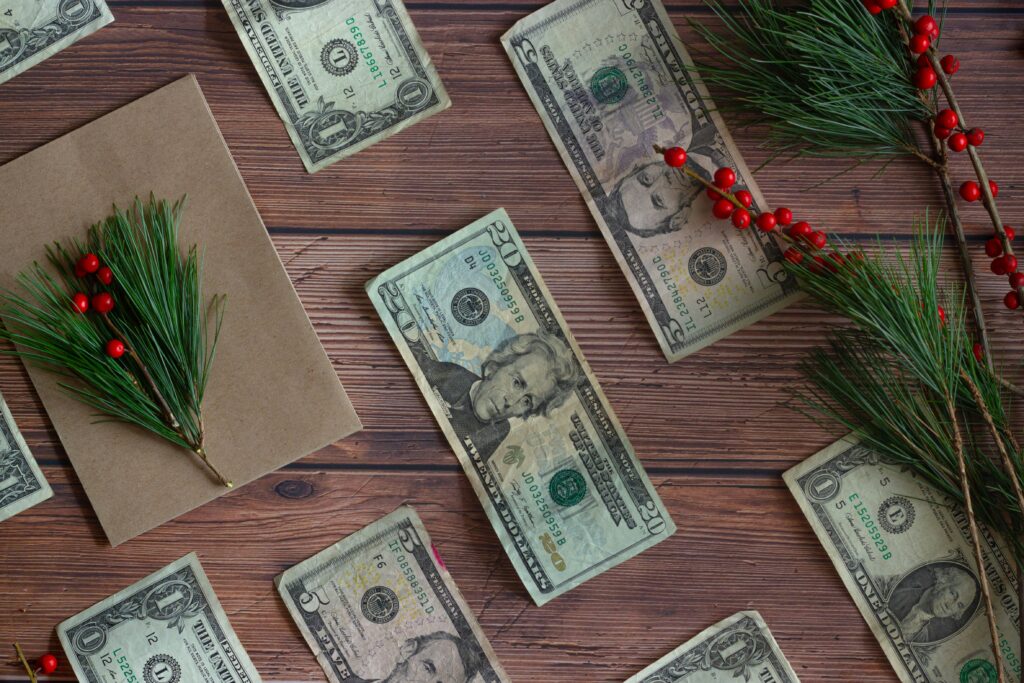 US Dollars lay on a table next to mistletoe