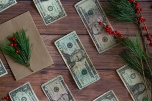 US Dollars lay on a table next to mistletoe