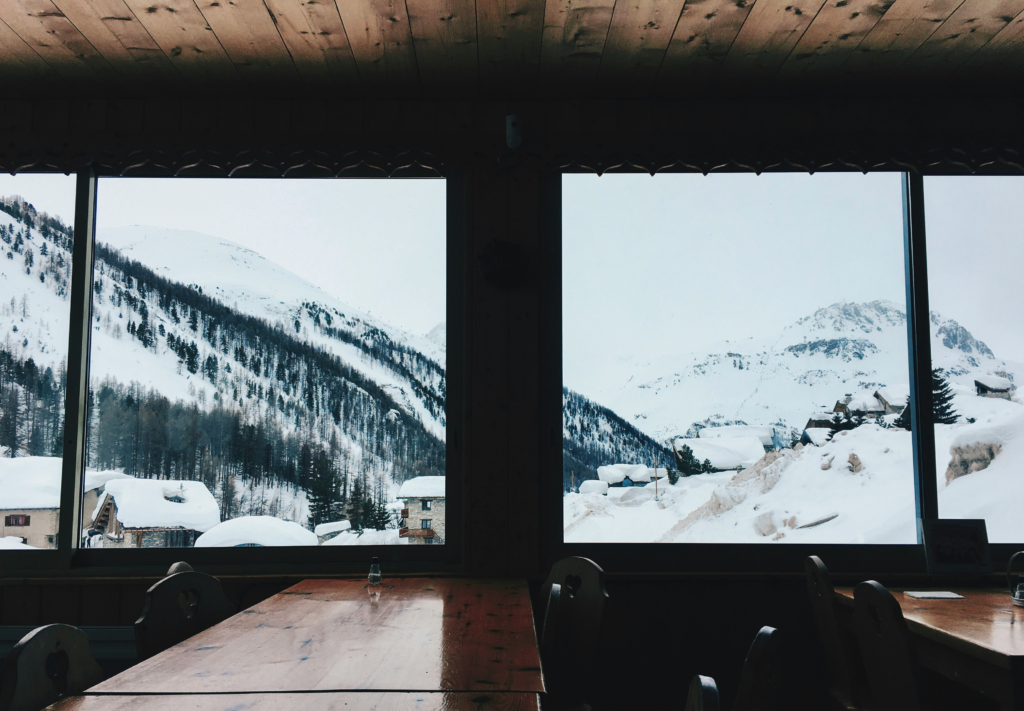 view of a snow covered mountain town from the inside of a dining hall