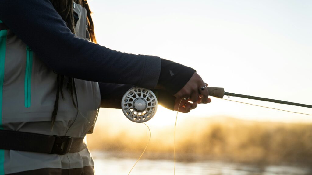 close up of a female fly fishing guide casting her line into the river