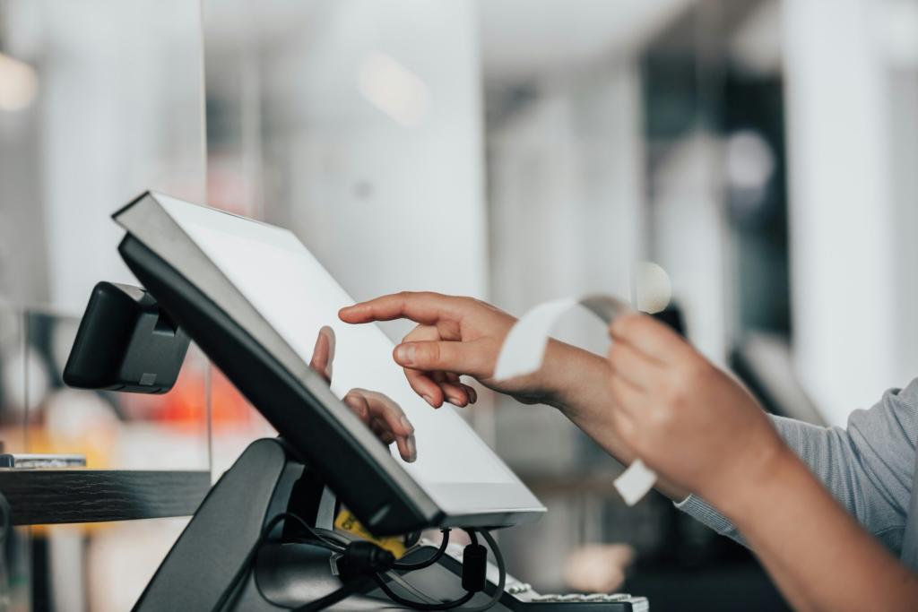 a front desk worker punches in numbers on a kiosk