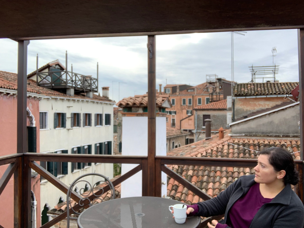 Having a coffee while enjoying the view from a balcony in Venice, Italy 