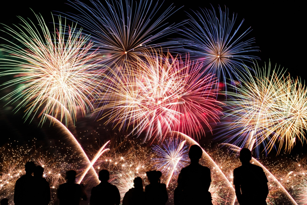 red, white, and blue fireworks light up the night sky