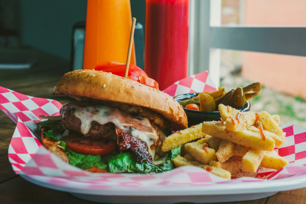 a classic American cheese burger on a plate with a side of steak fries