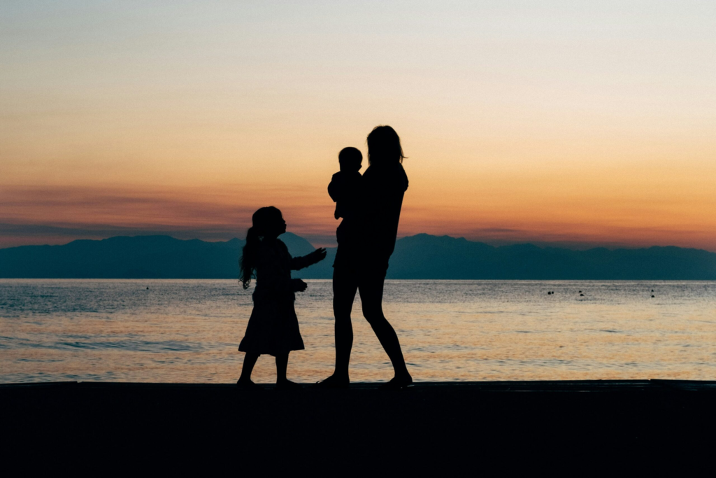 silhouette of two children on a beach with their Au Pair